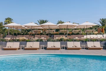 a pool with lounge chairs and umbrellas