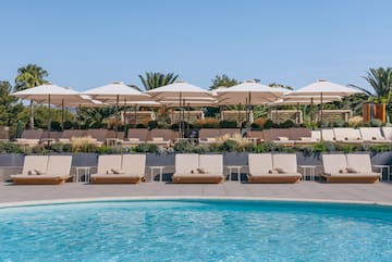 a pool with lounge chairs and umbrellas