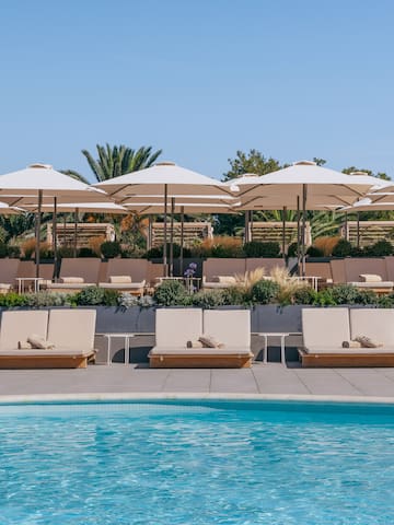a pool with lounge chairs and umbrellas