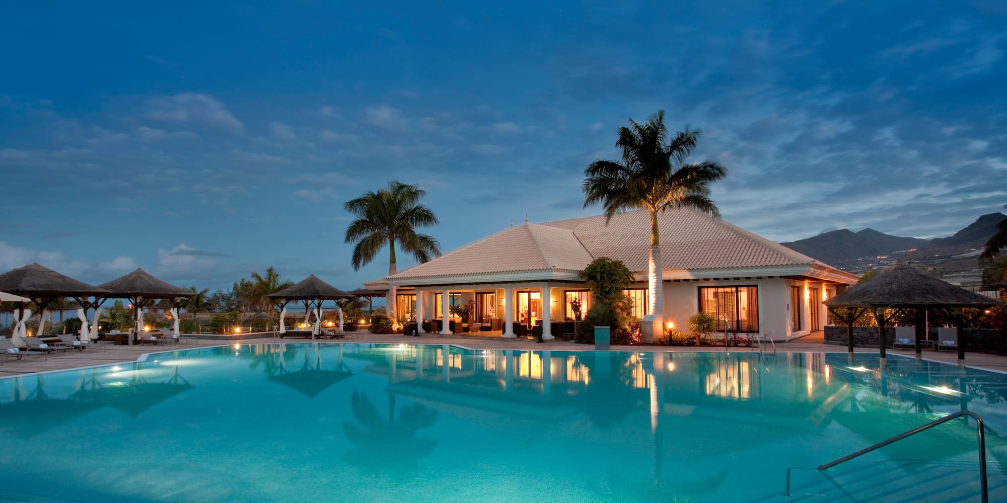 a pool with a building and palm trees