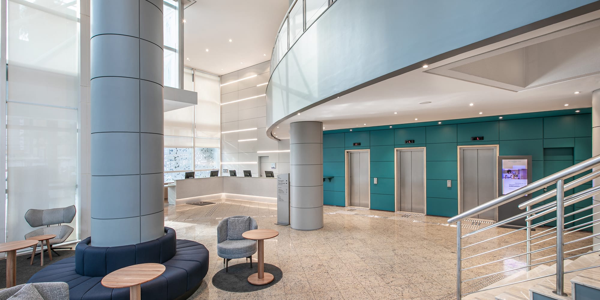 a lobby with a staircase and chairs