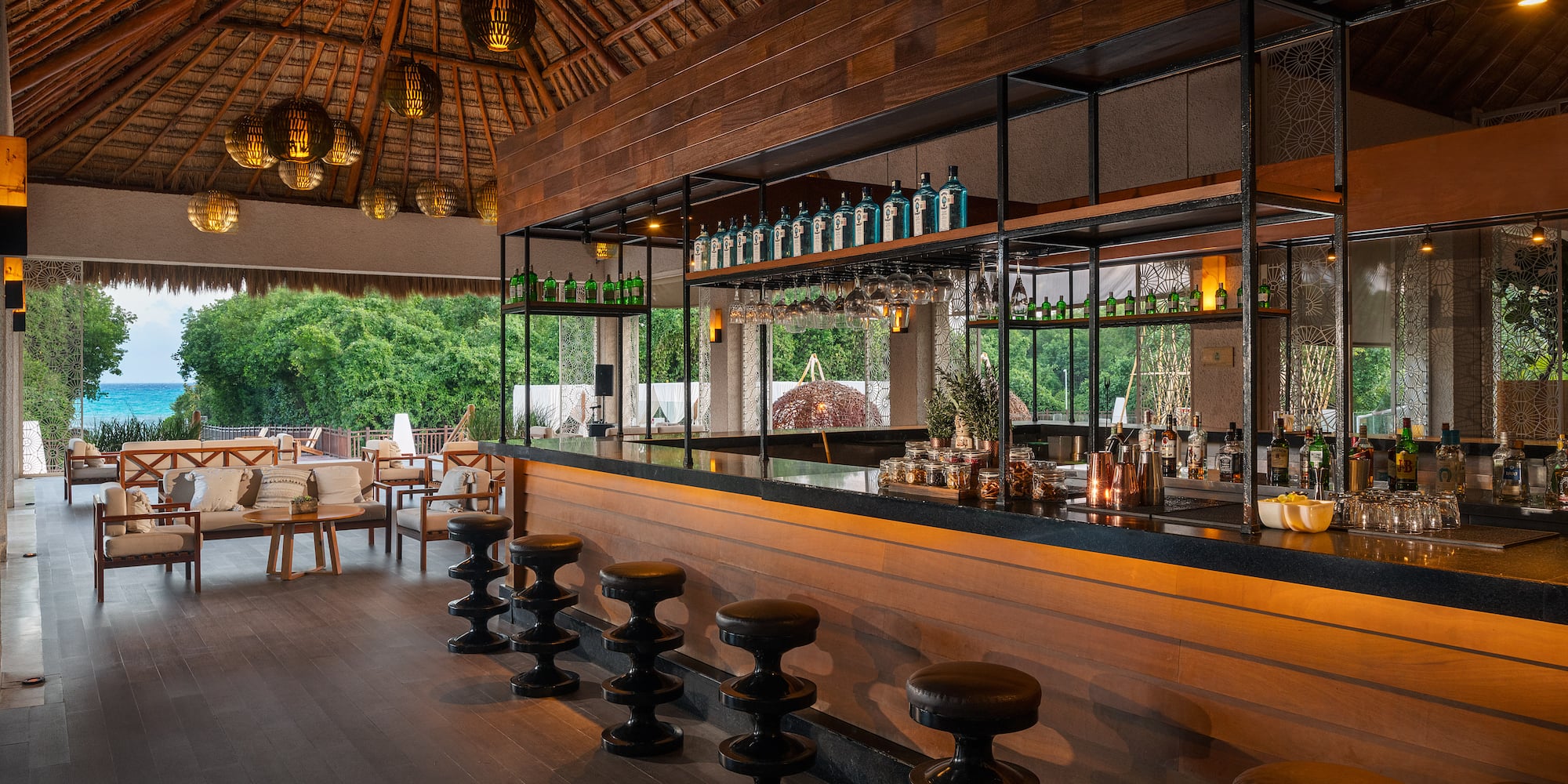 a bar with stools and bottles of alcohol