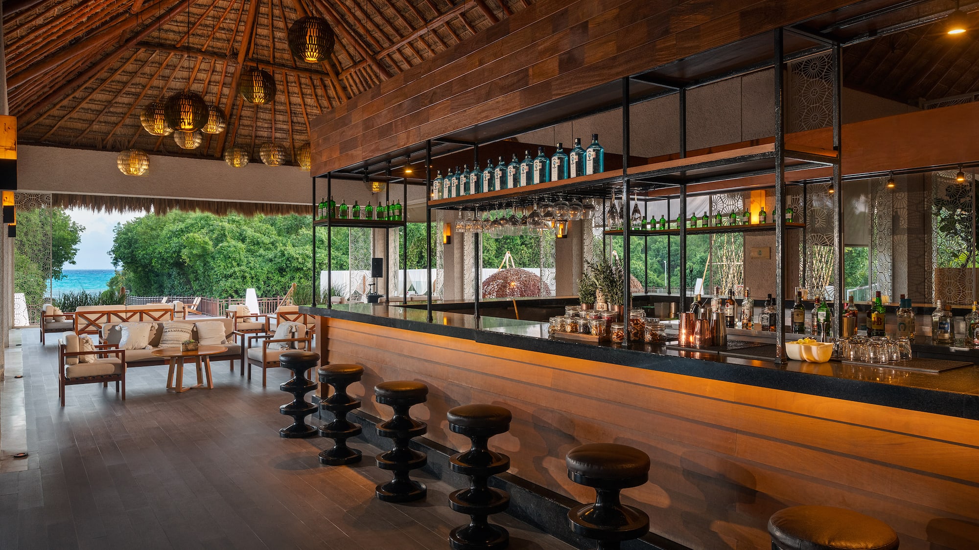 a bar with stools and bottles of alcohol