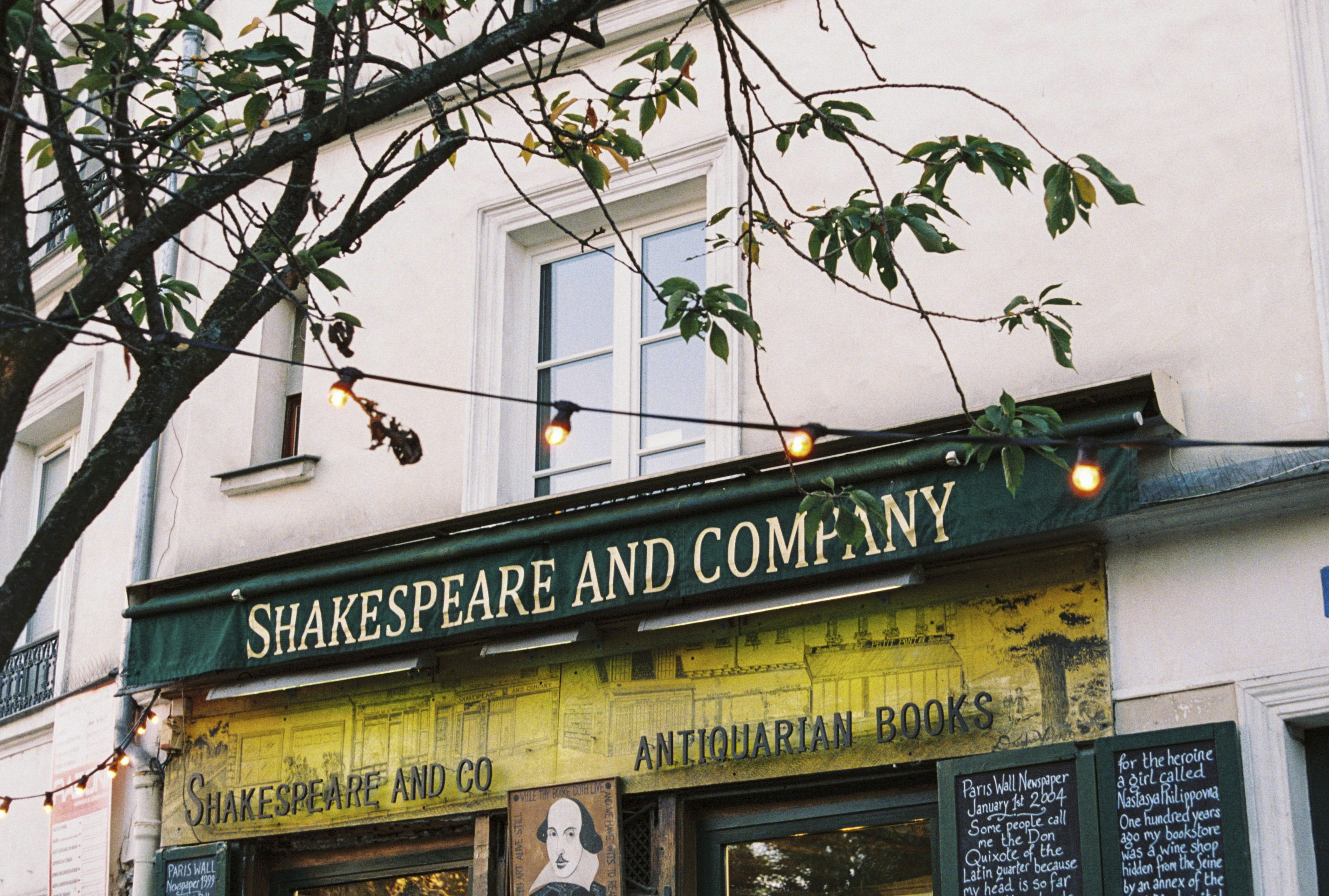 a store front with a sign and string of lights