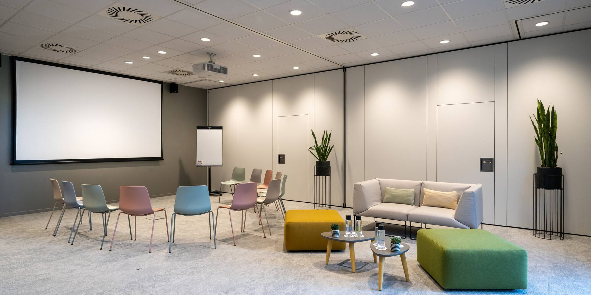 a room with a white screen and chairs