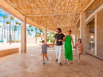 a family walking under a bamboo canopy