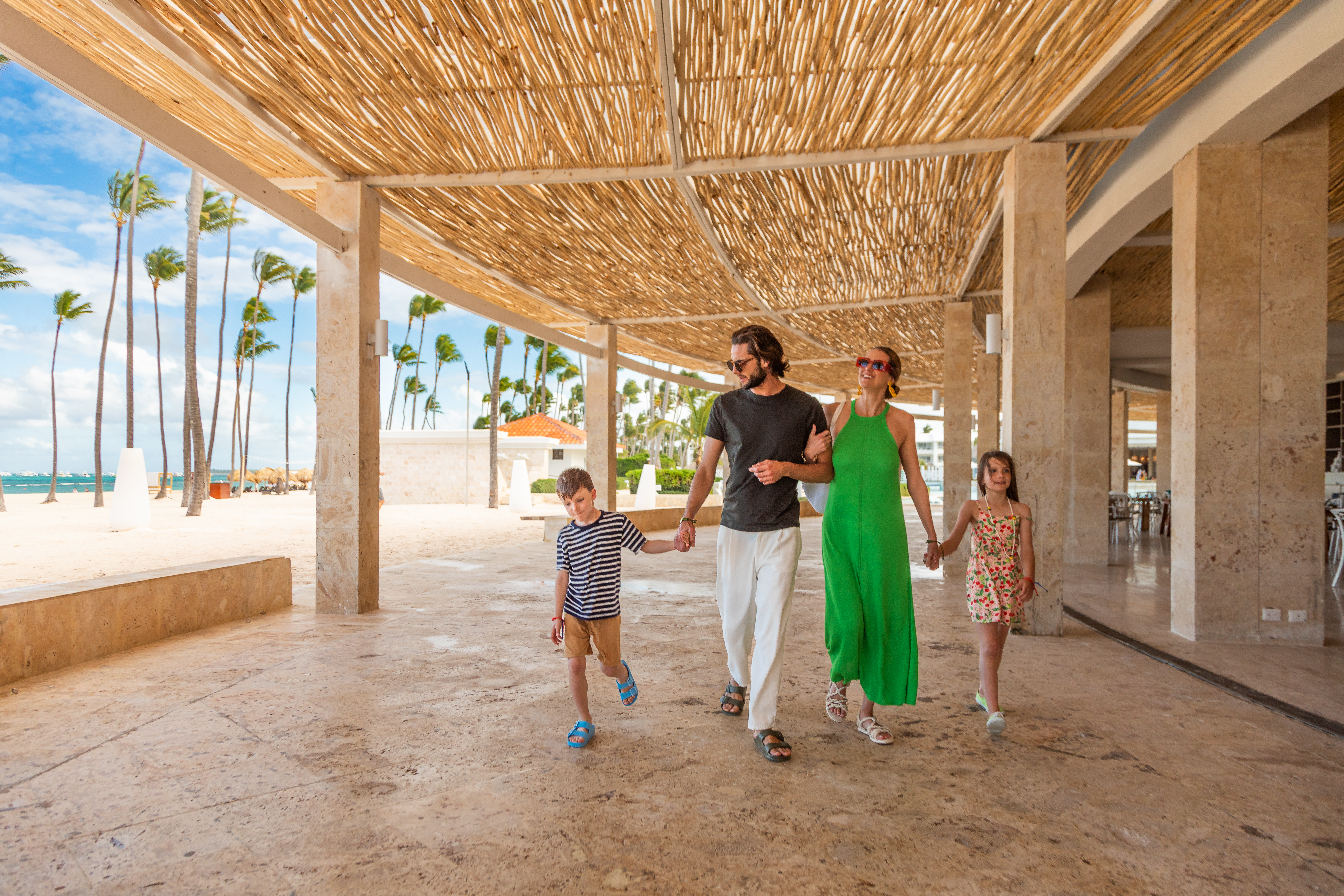 a family walking under a bamboo canopy