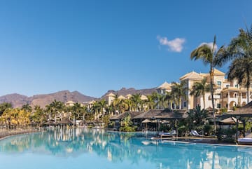 a pool with palm trees and buildings in the background