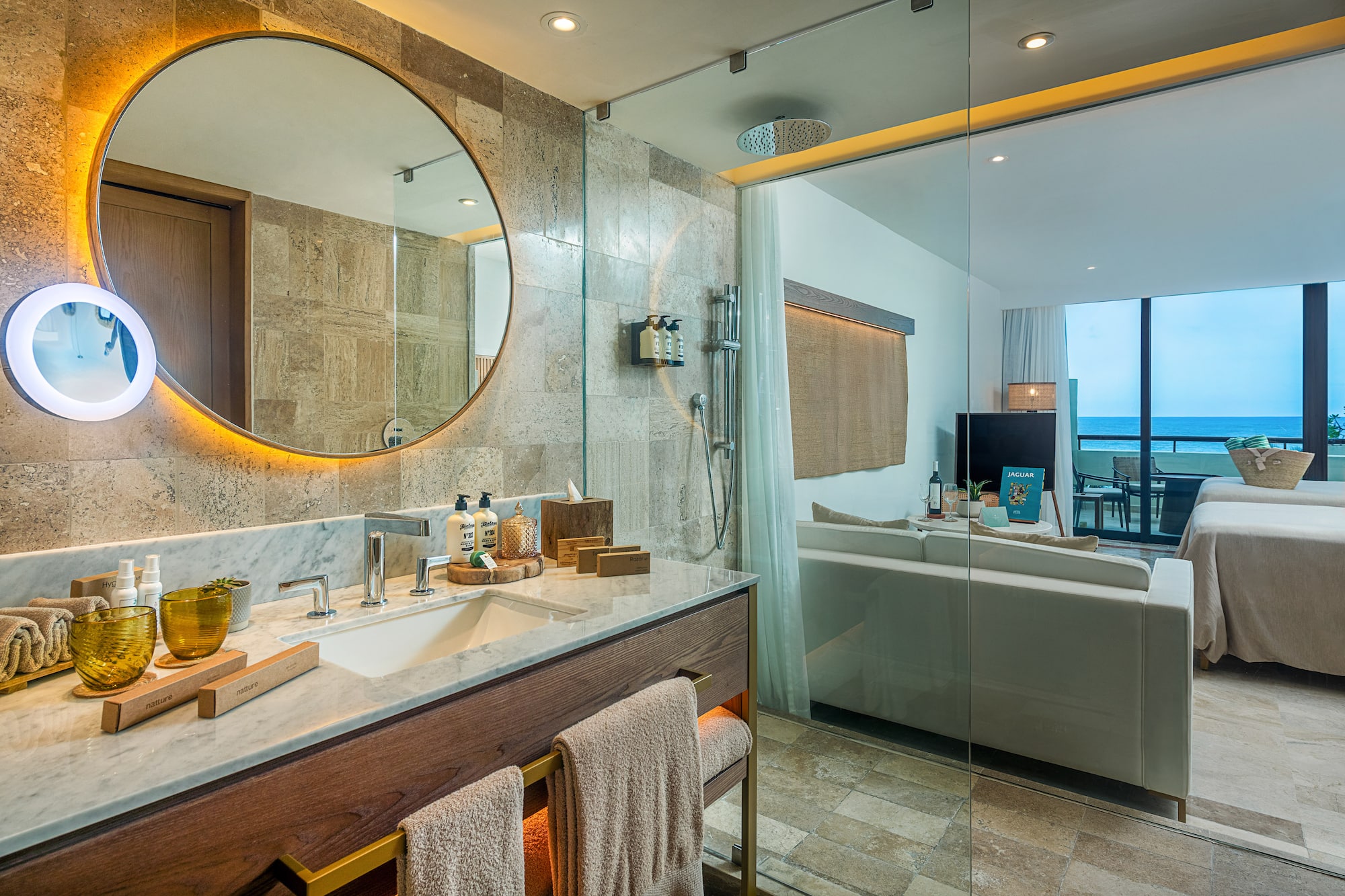 a bathroom with a large round mirror and a bathtub