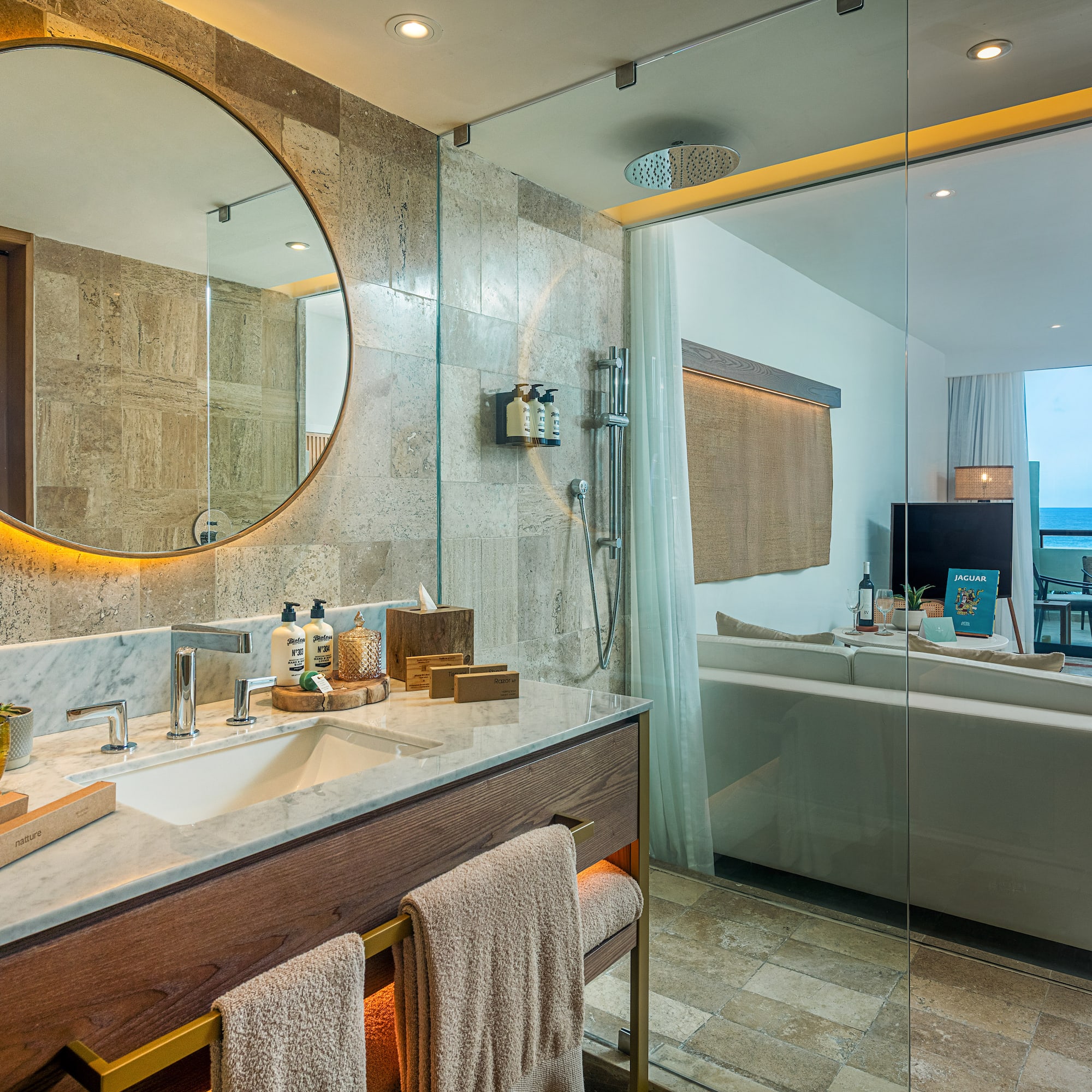 a bathroom with a large round mirror and a bathtub