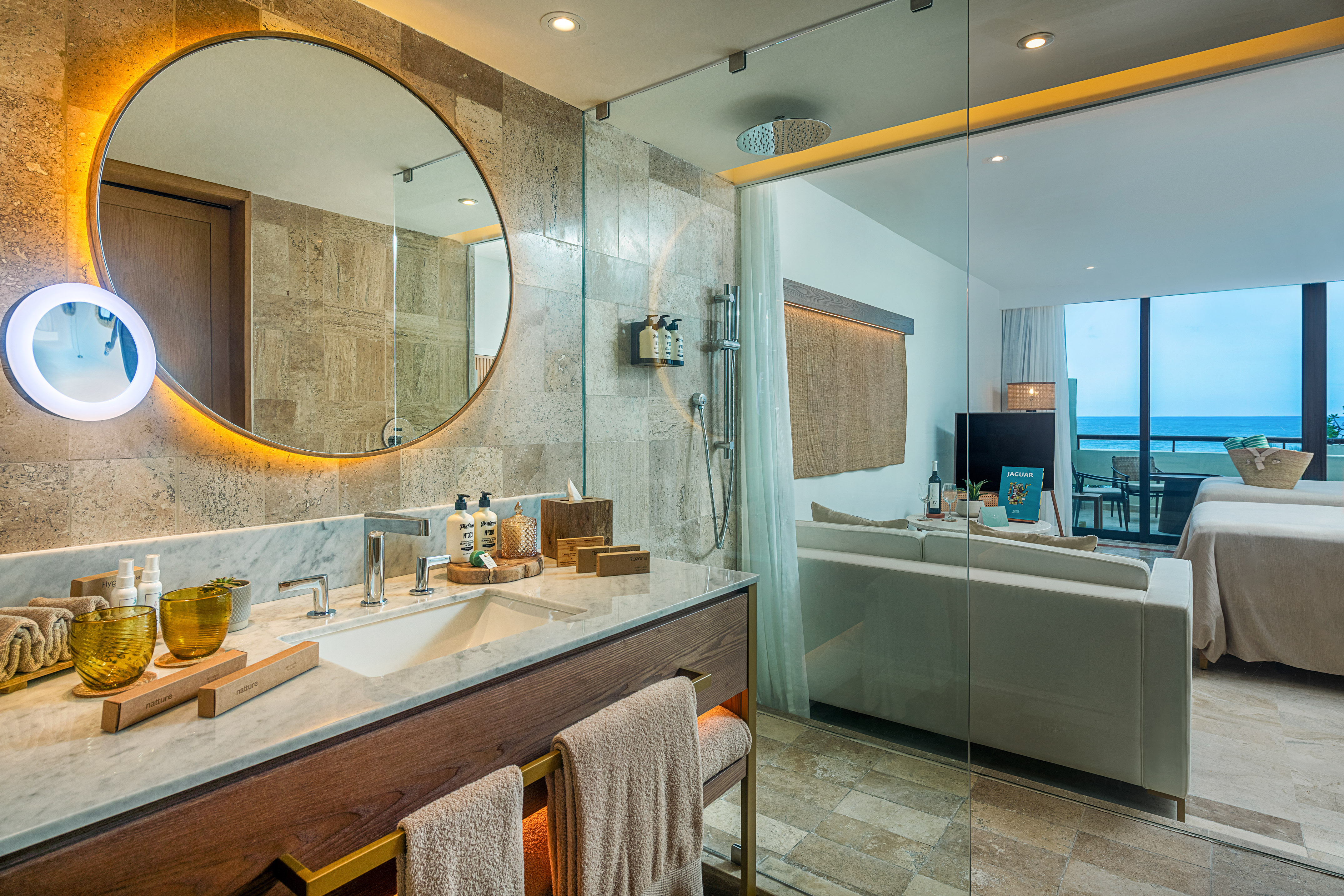 a bathroom with a large round mirror and a bathtub