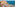 Oceanfront hotel with pool, sunbeds, and clear blue sea.