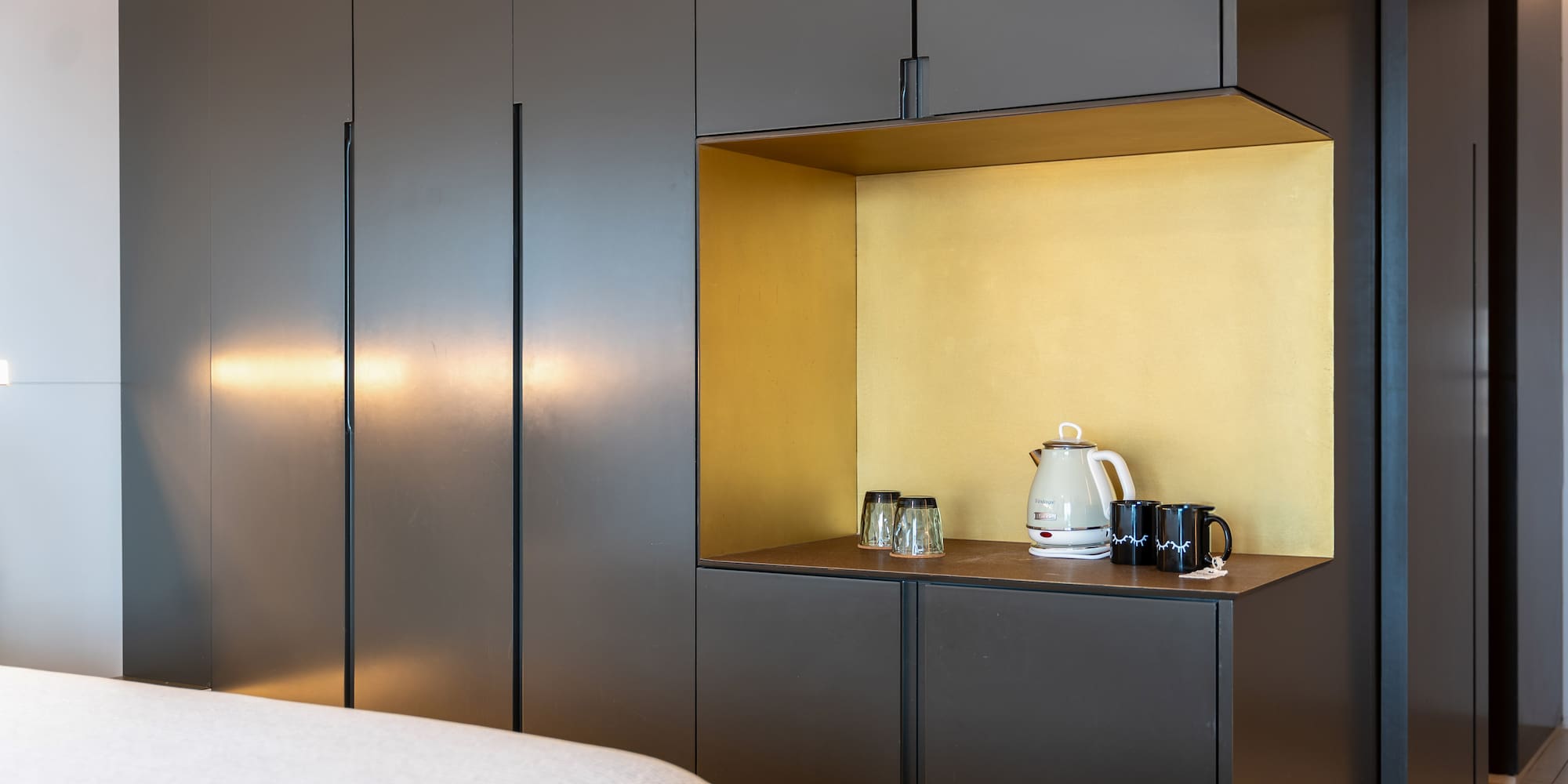 a room with a bed and a coffee pot