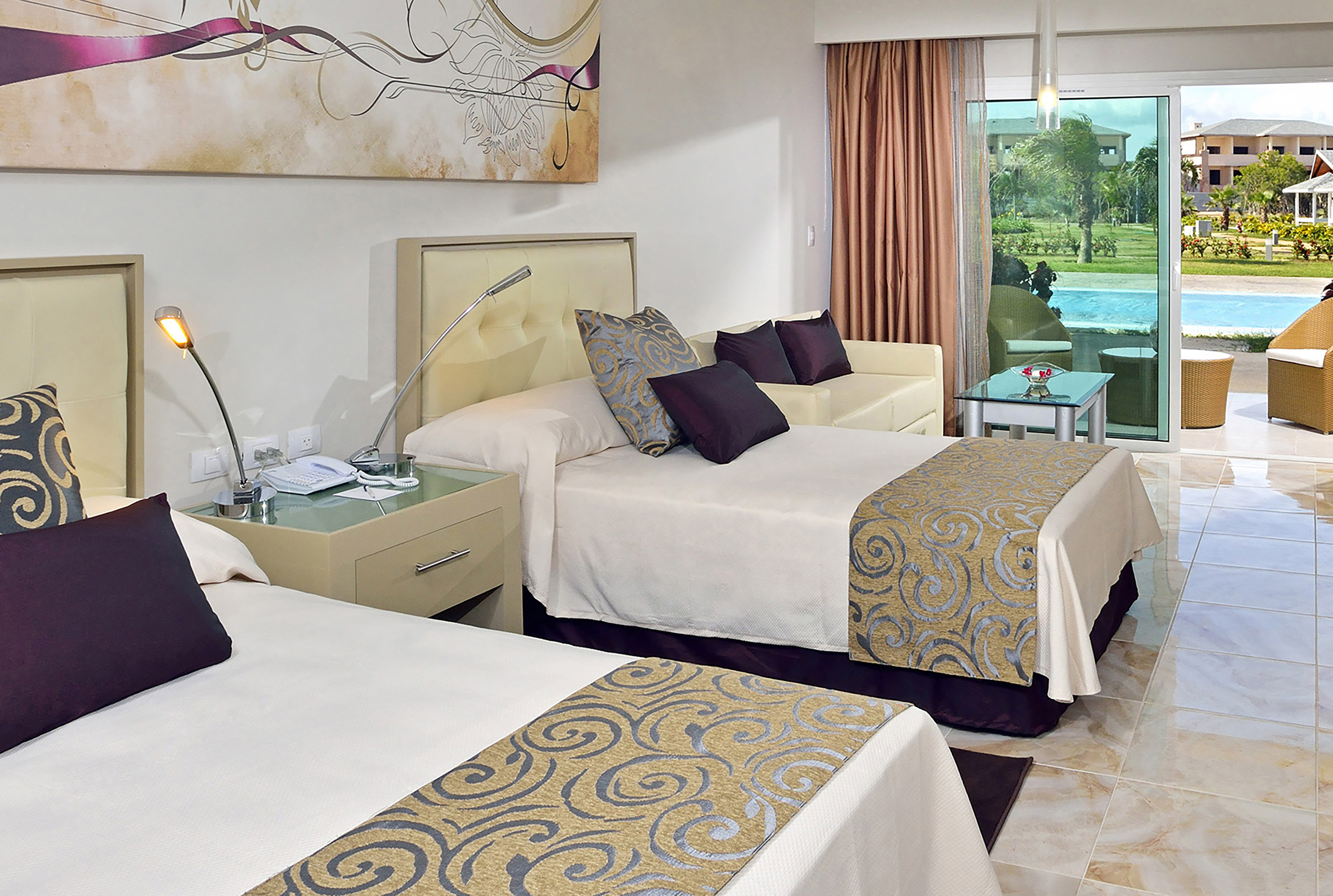 a room with two beds and a pool in the background