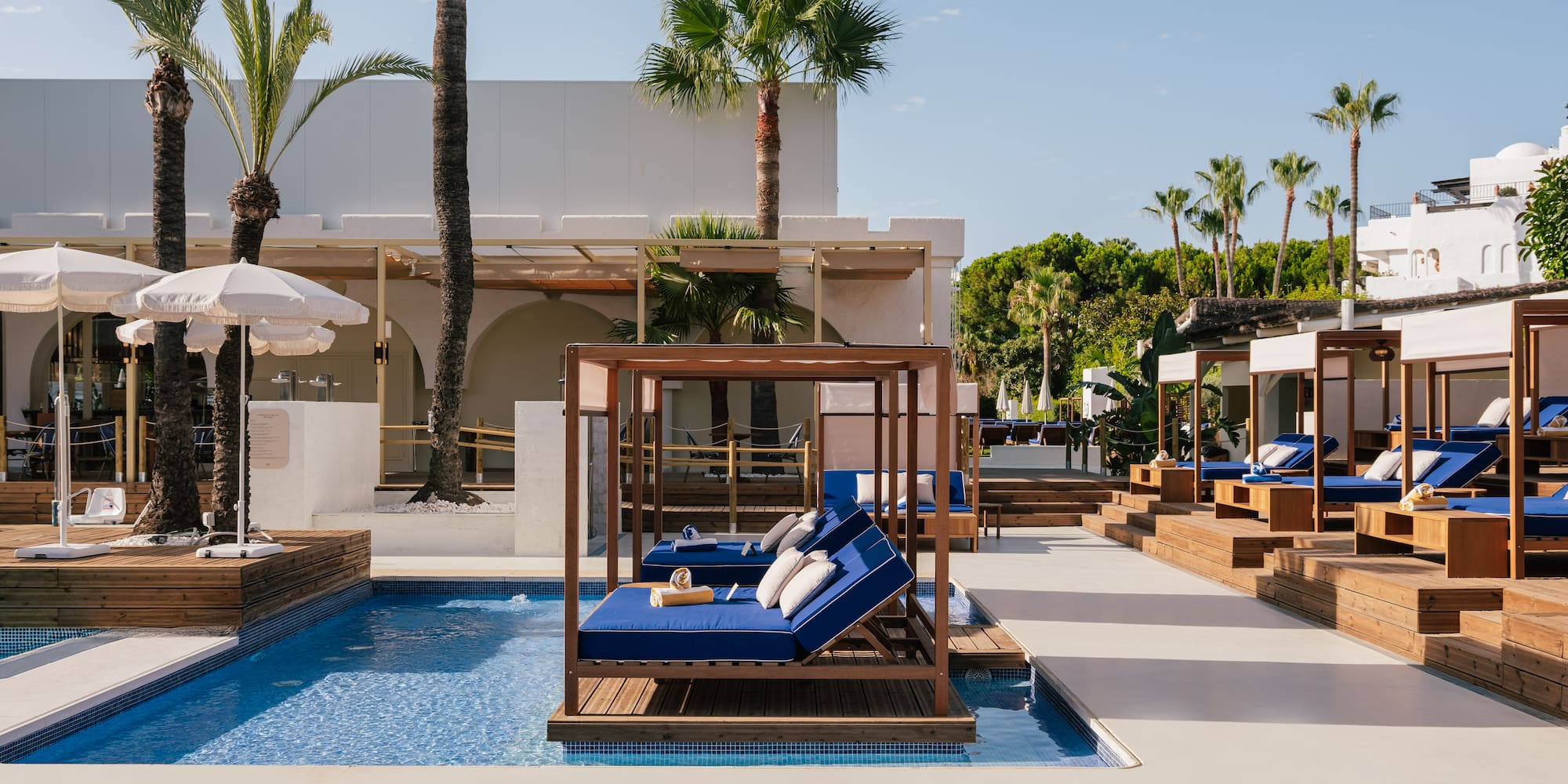 a pool with lounge chairs and umbrellas