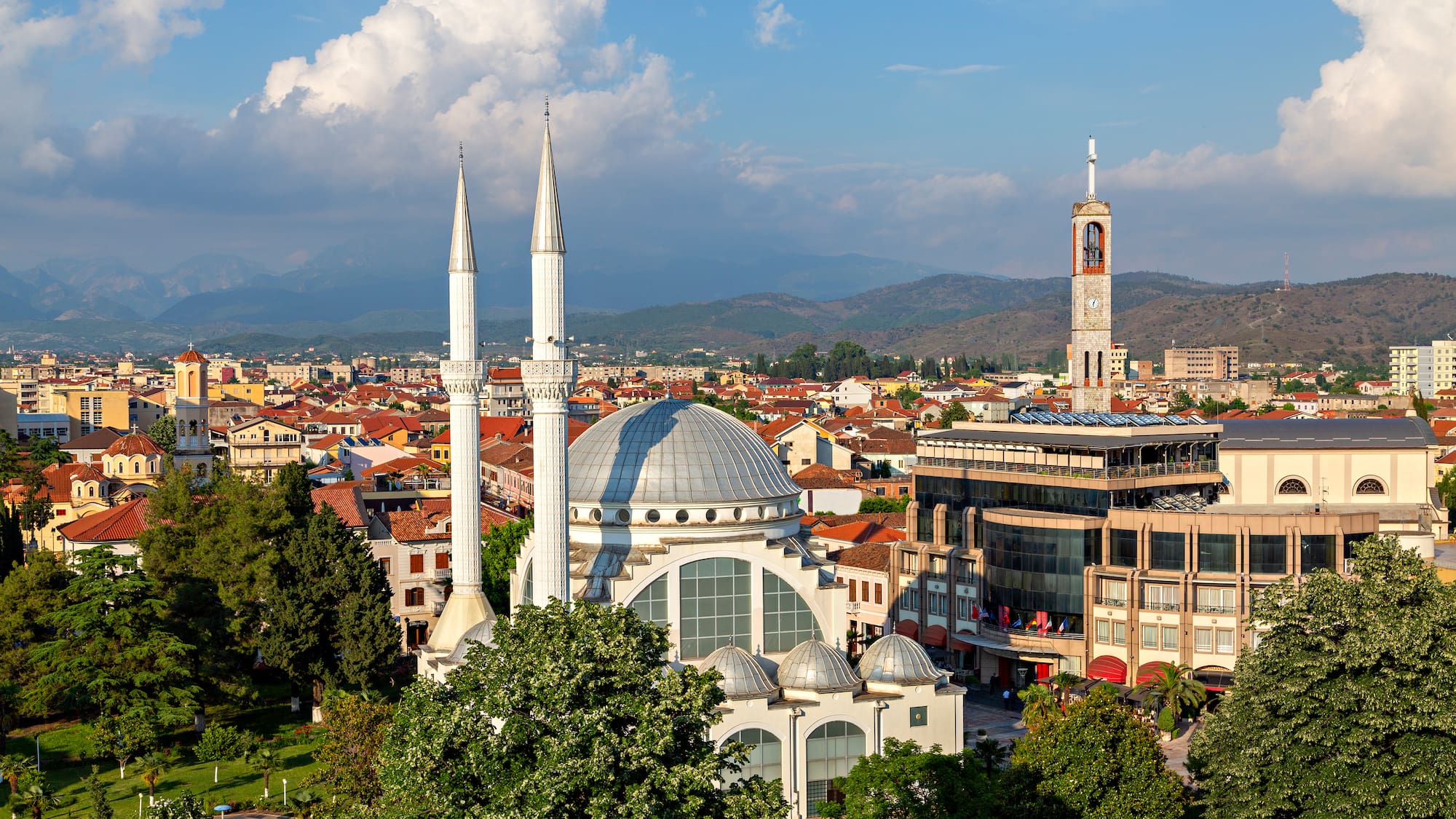 a large white building with towers and a large building in the background