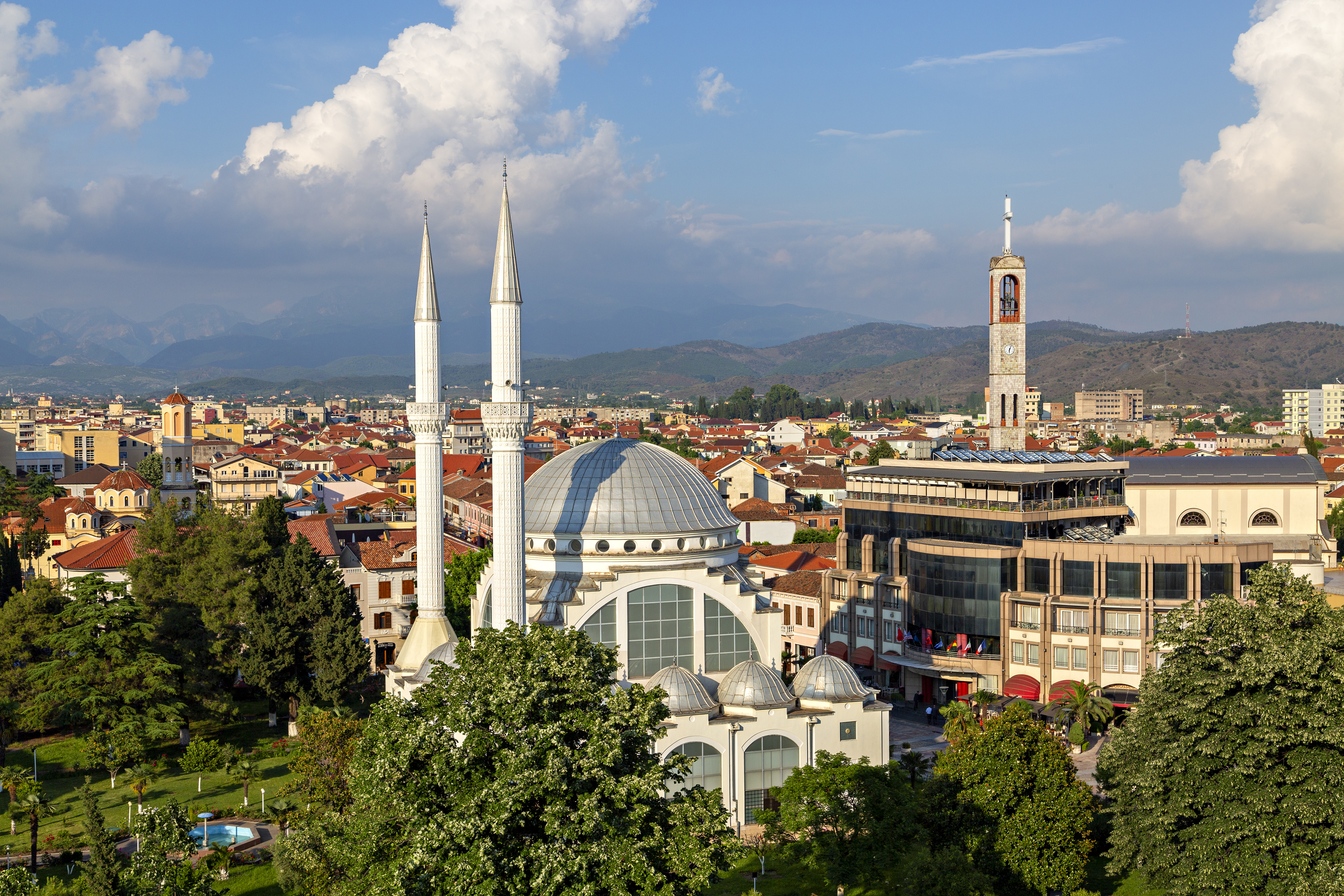 a large white building with towers and a large building in the background