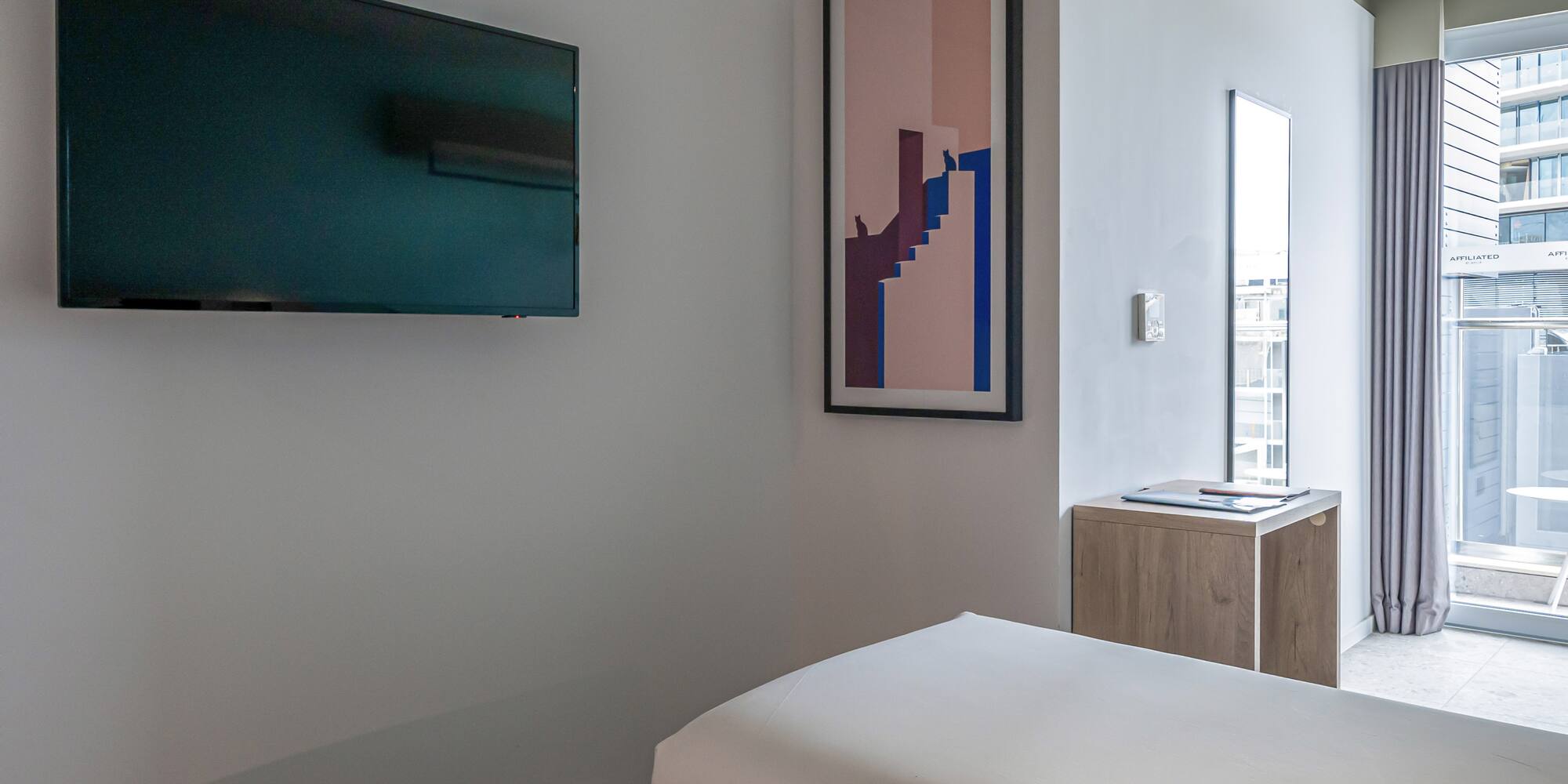 a room with two beds and a tv on the wall