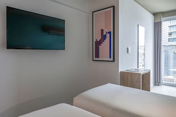 a room with two beds and a tv on the wall