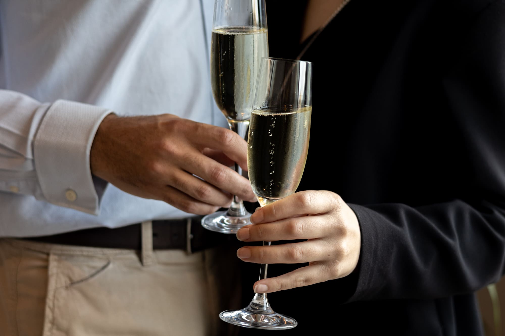 Pareja elegante brindando con copas de champán.