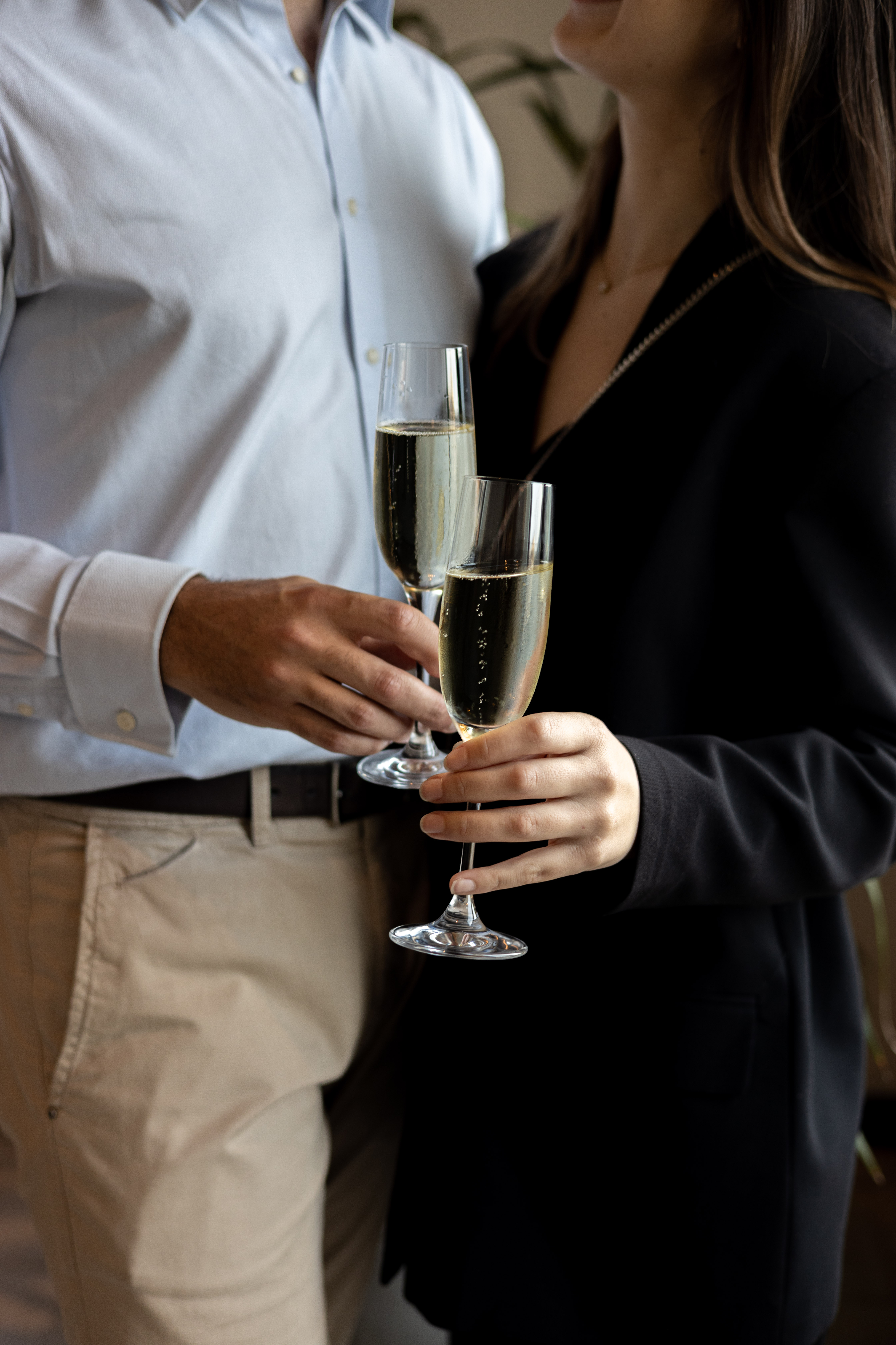 Pareja elegante brindando con copas de champán.