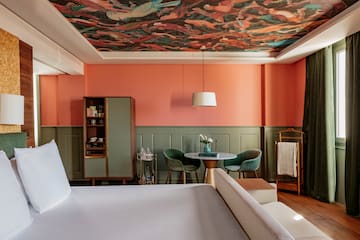 a room with a bed and a table and chairs
