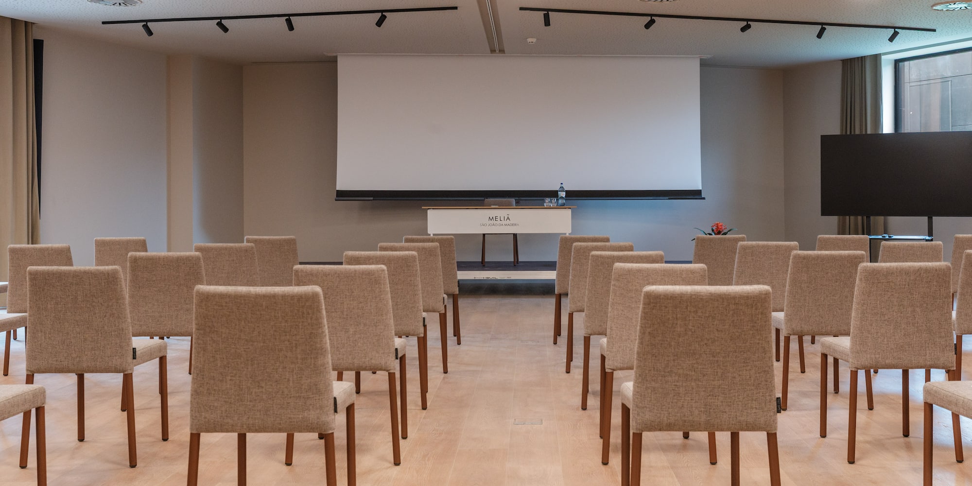 a room with chairs and a projector screen