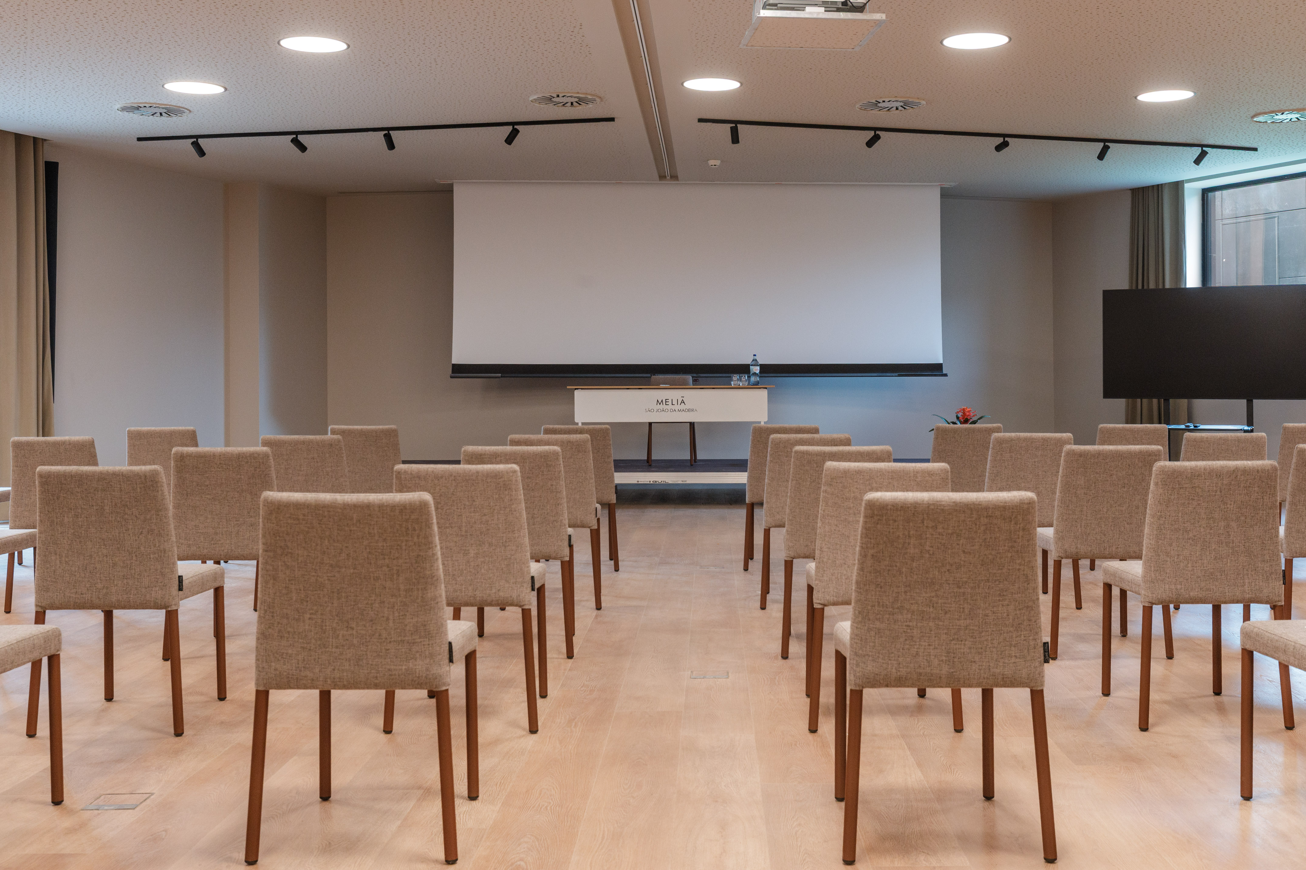 a room with chairs and a projector screen
