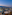 Rooftop lounge with twilight city view, distant mountains, and stylish seating.