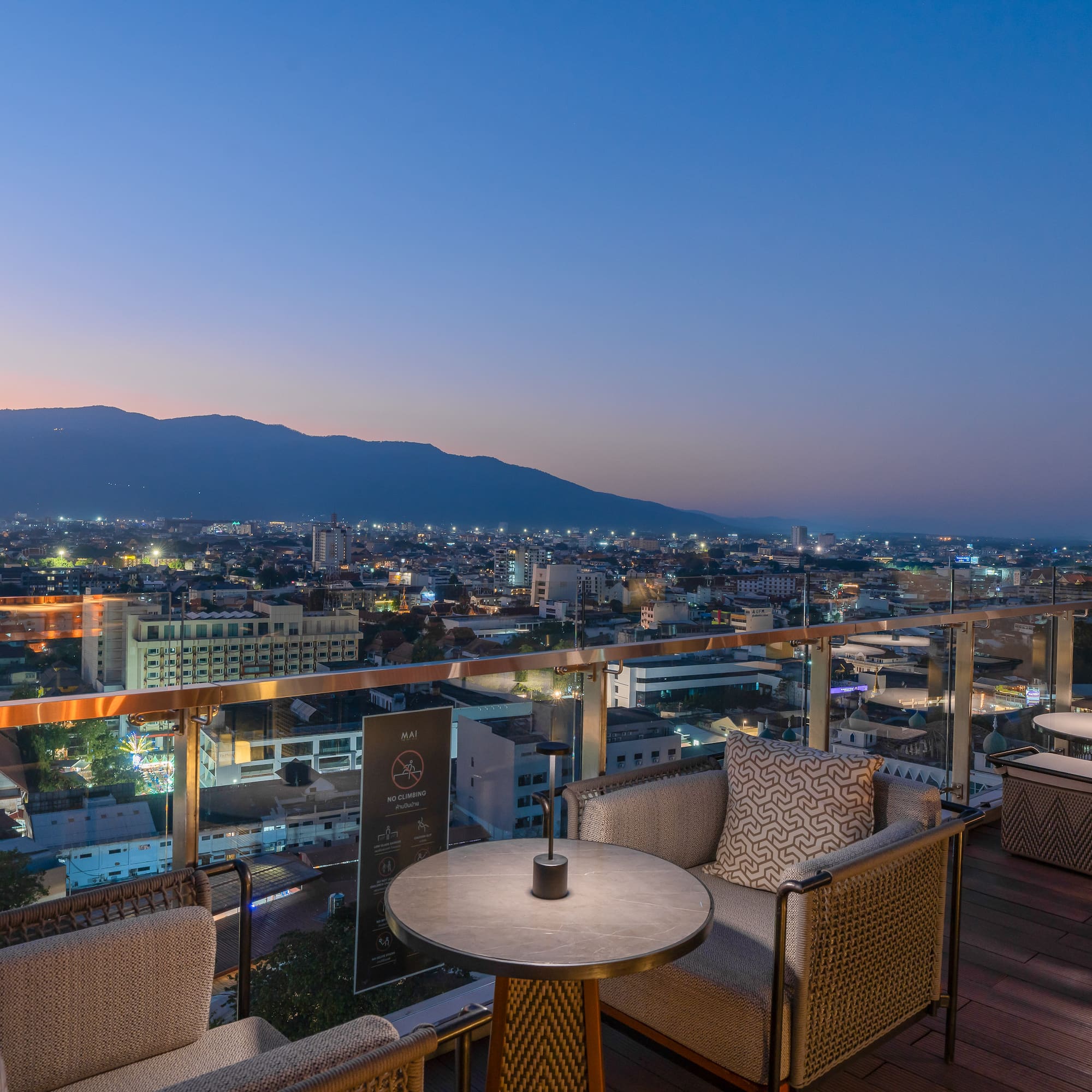 a table and chairs on a rooftop overlooking a city