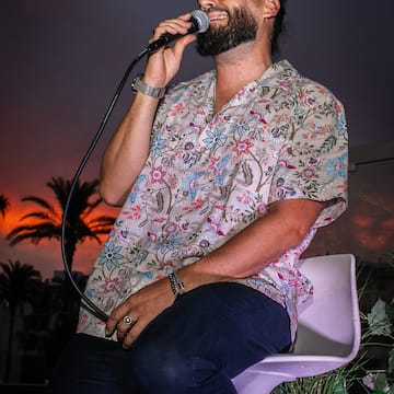 a man sitting on a chair holding a microphone