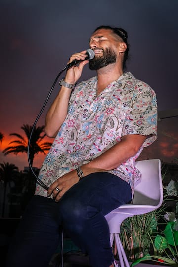 a man sitting on a chair holding a microphone