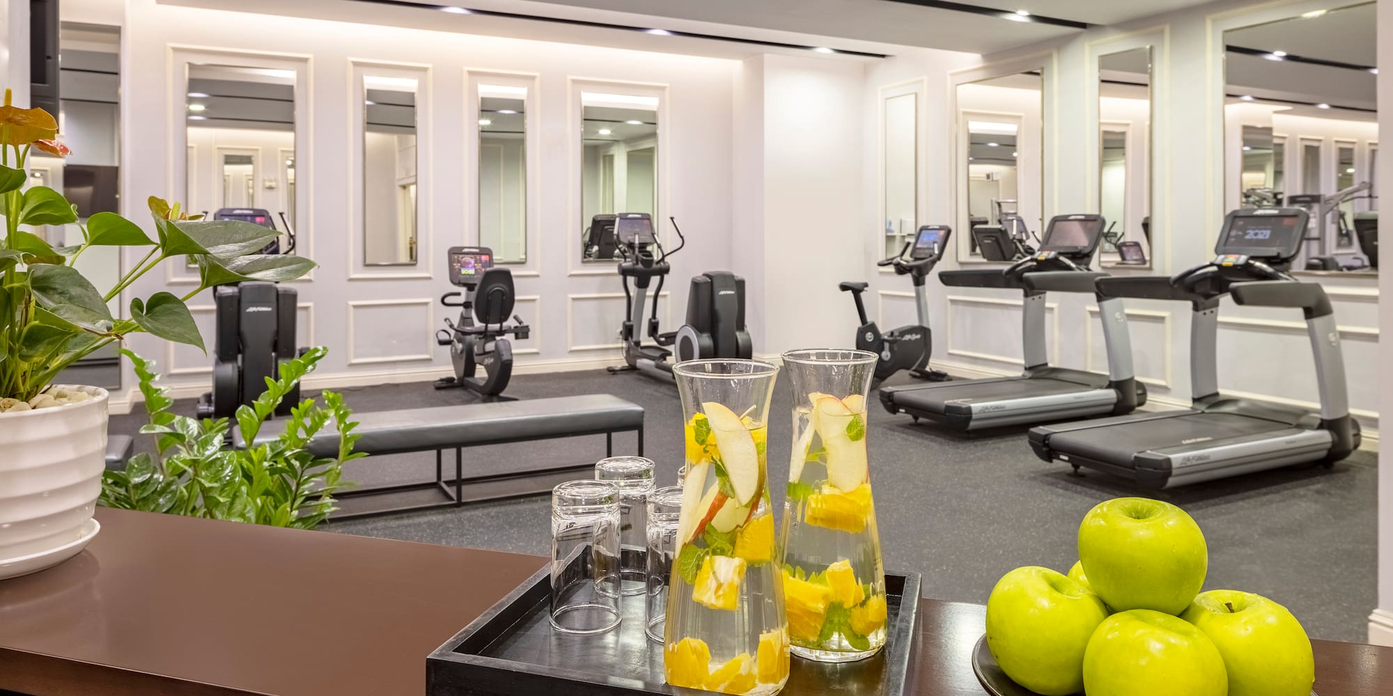 a room with exercise machines and a bowl of fruit