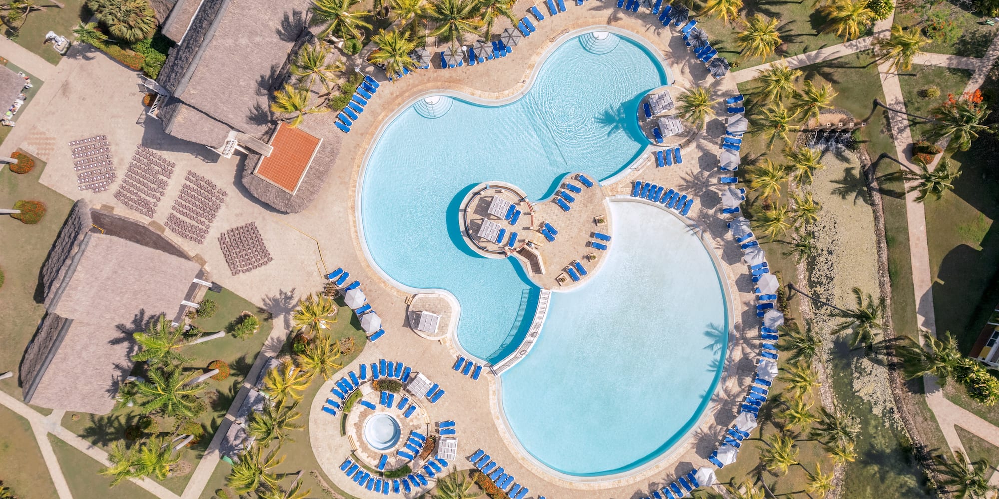 a swimming pool with chairs and a pool in the middle