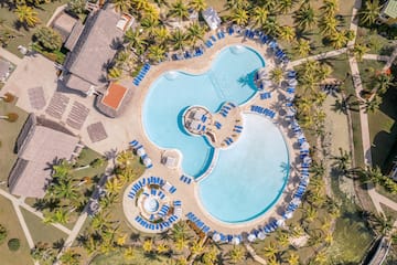 a swimming pool with chairs and a pool in the middle