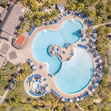 a swimming pool with chairs and a pool in the middle