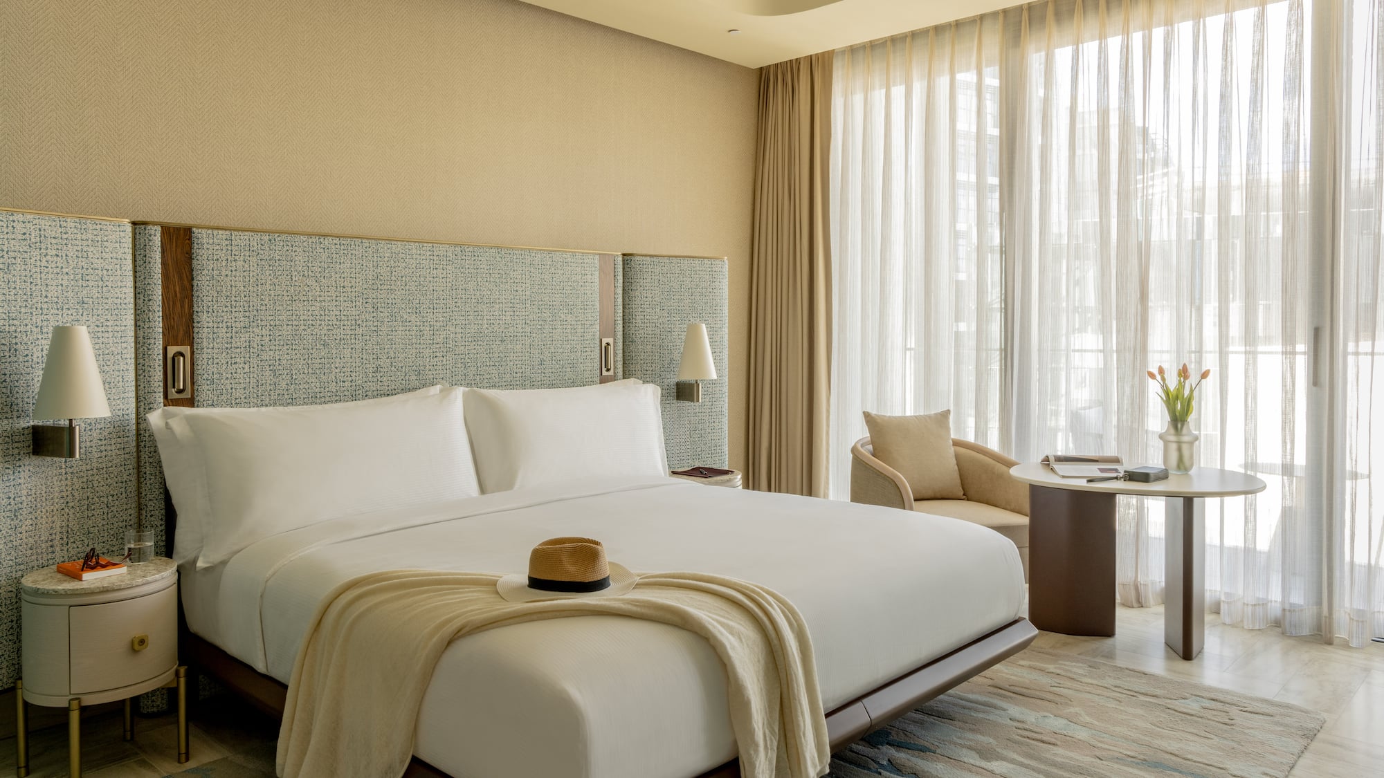 Modern luxury hotel room with king bed, elegant design, and sunlit window.