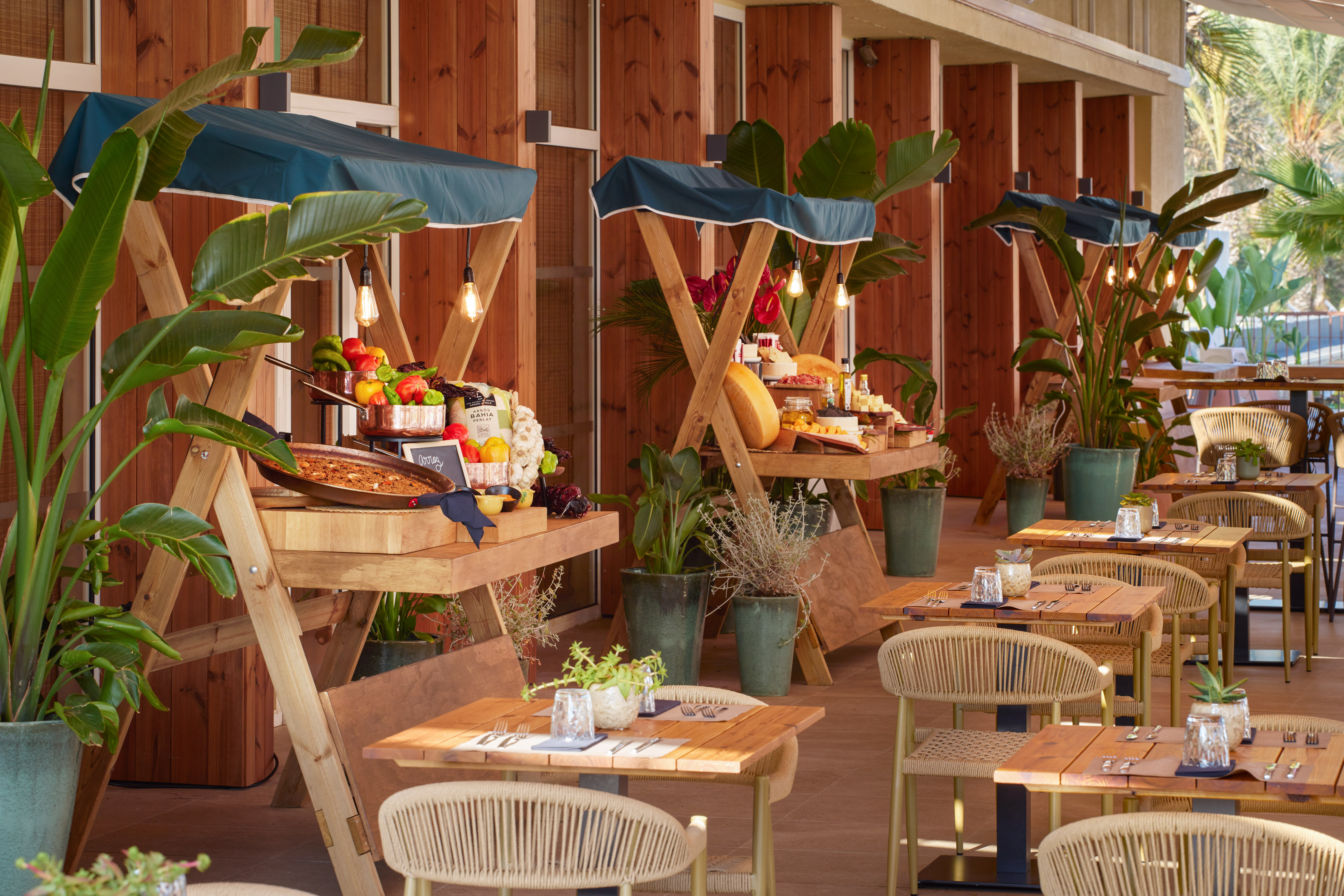 Outdoor restaurant buffet featuring fresh food stalls and tropical decor.