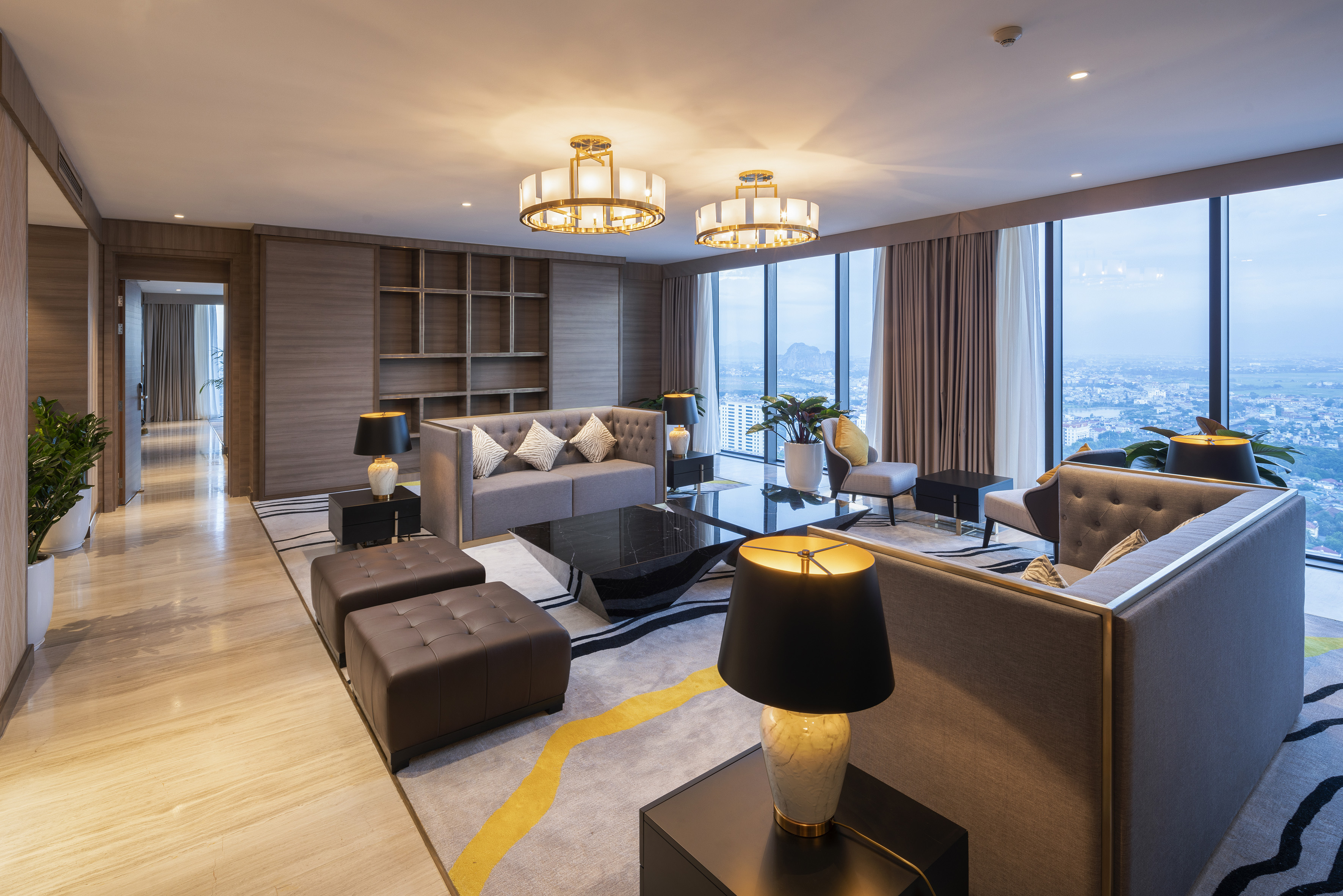 High-rise luxury living room, panoramic city view, contemporary gray sofas.