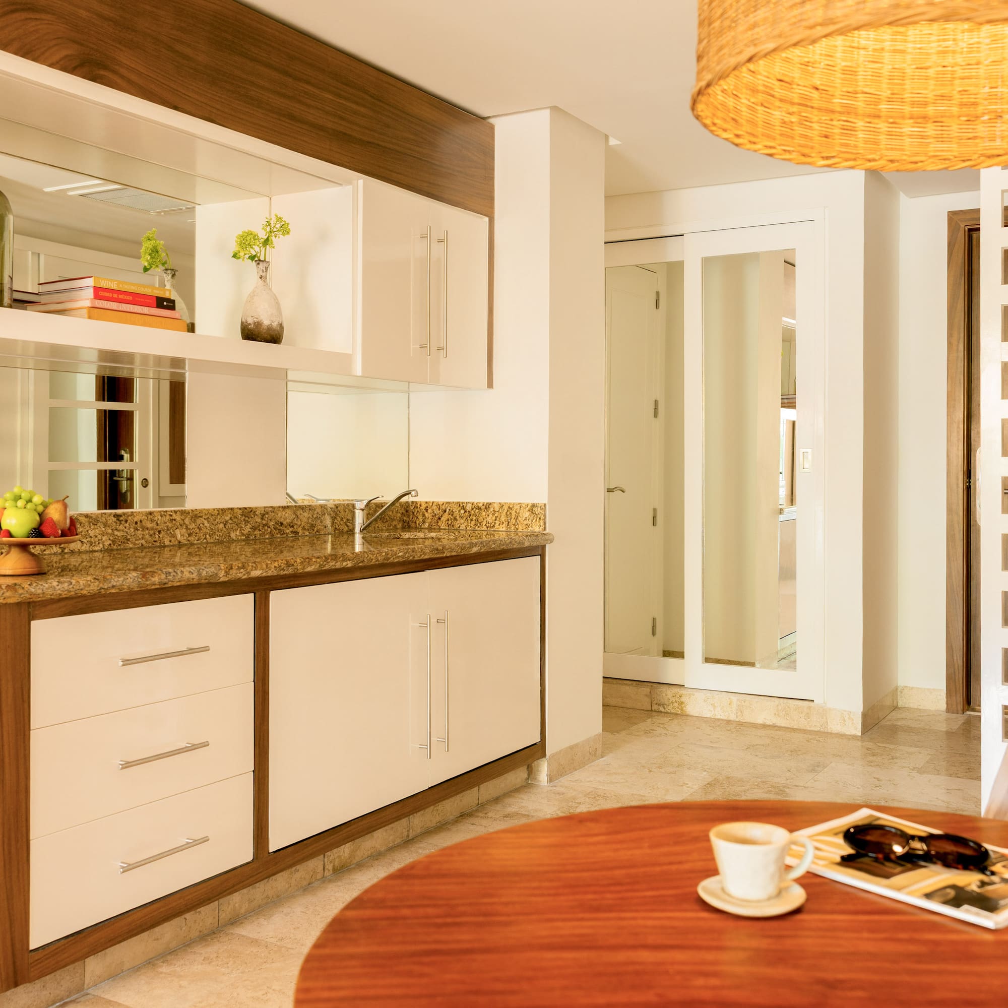 Modern kitchenette and dining area with granite counter and wood cabinets.
