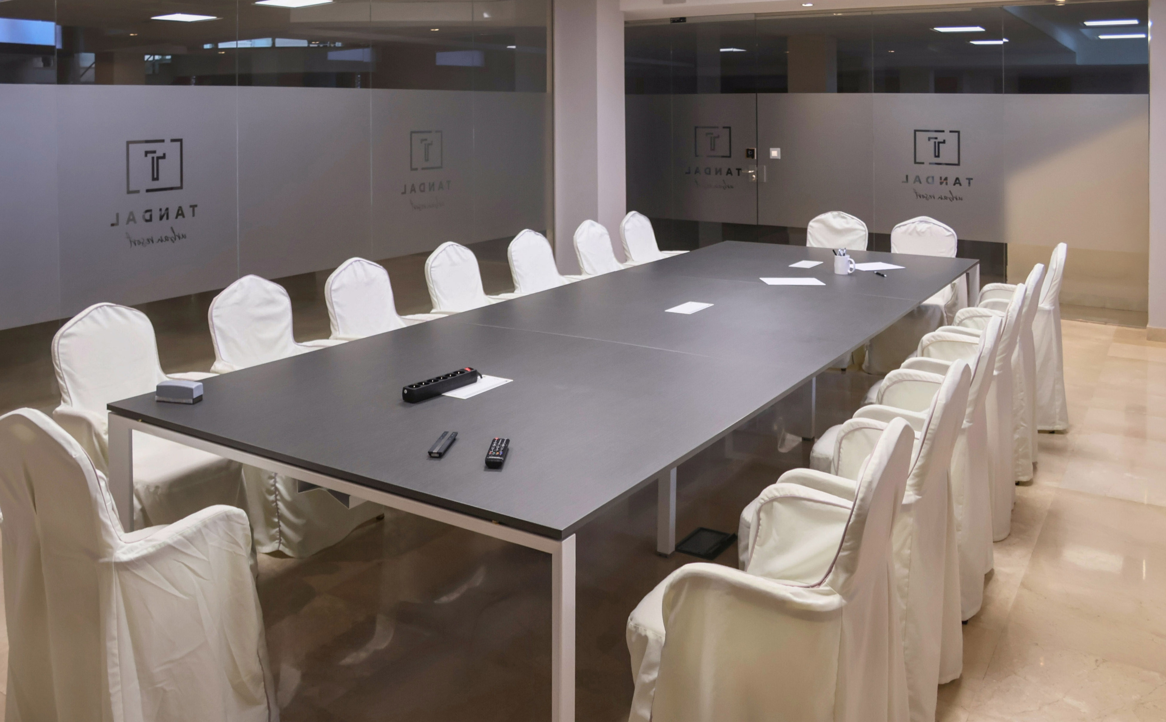 Modern Jagnet conference room with long dark table and white chairs.
