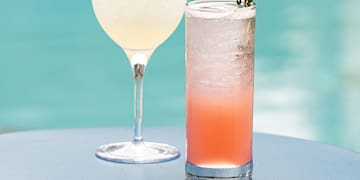 two glasses of drinks on a table