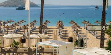 a pool with umbrellas and chairs on a beach