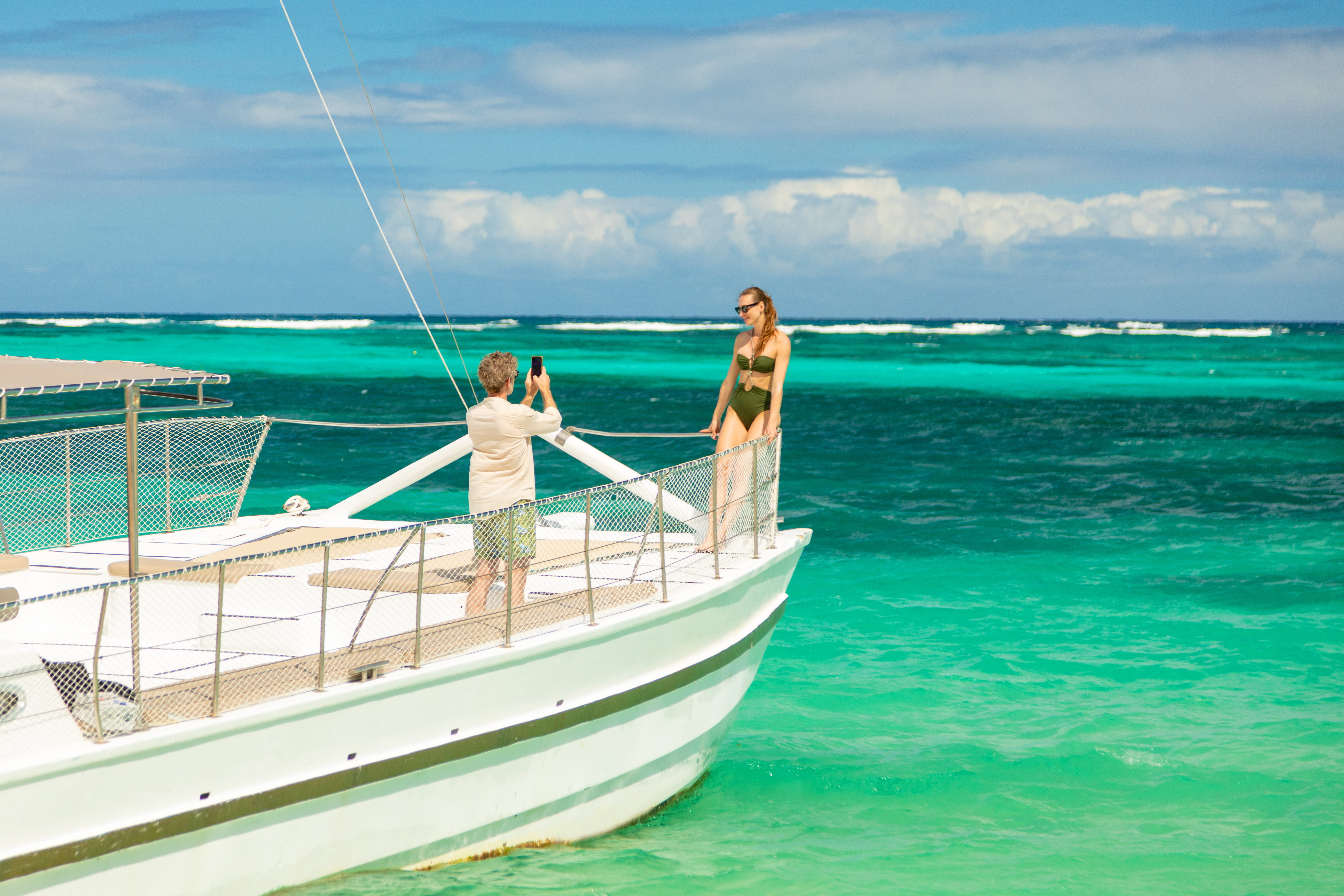 a man taking a picture of a woman on a boat