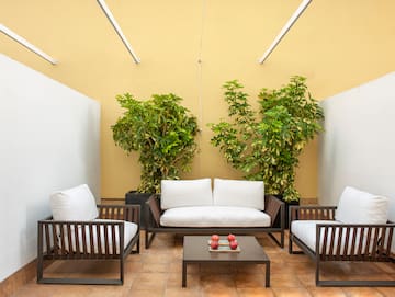 a patio with white couches and a table
