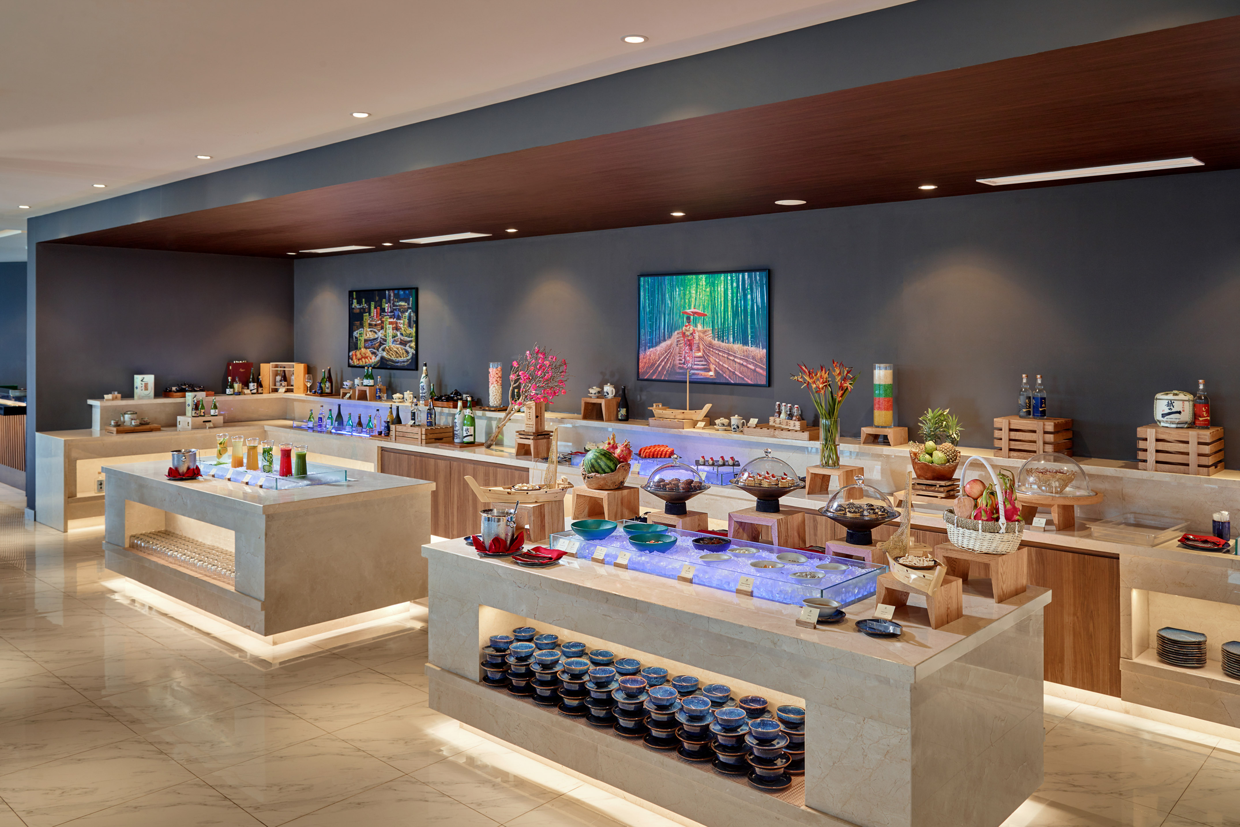 Modern hotel buffet with fresh juices and varied food displays.