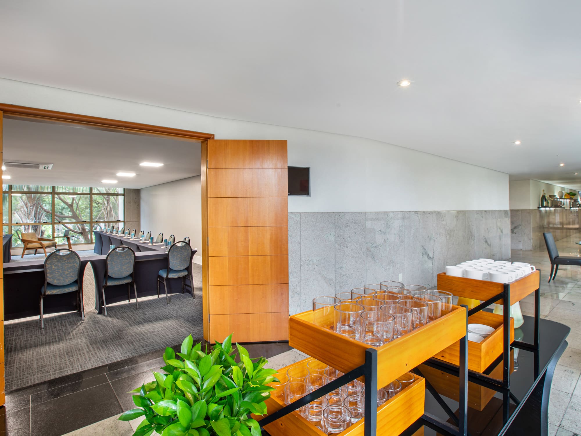 Hotel conference room with U-shaped table, adjacent refreshment station.