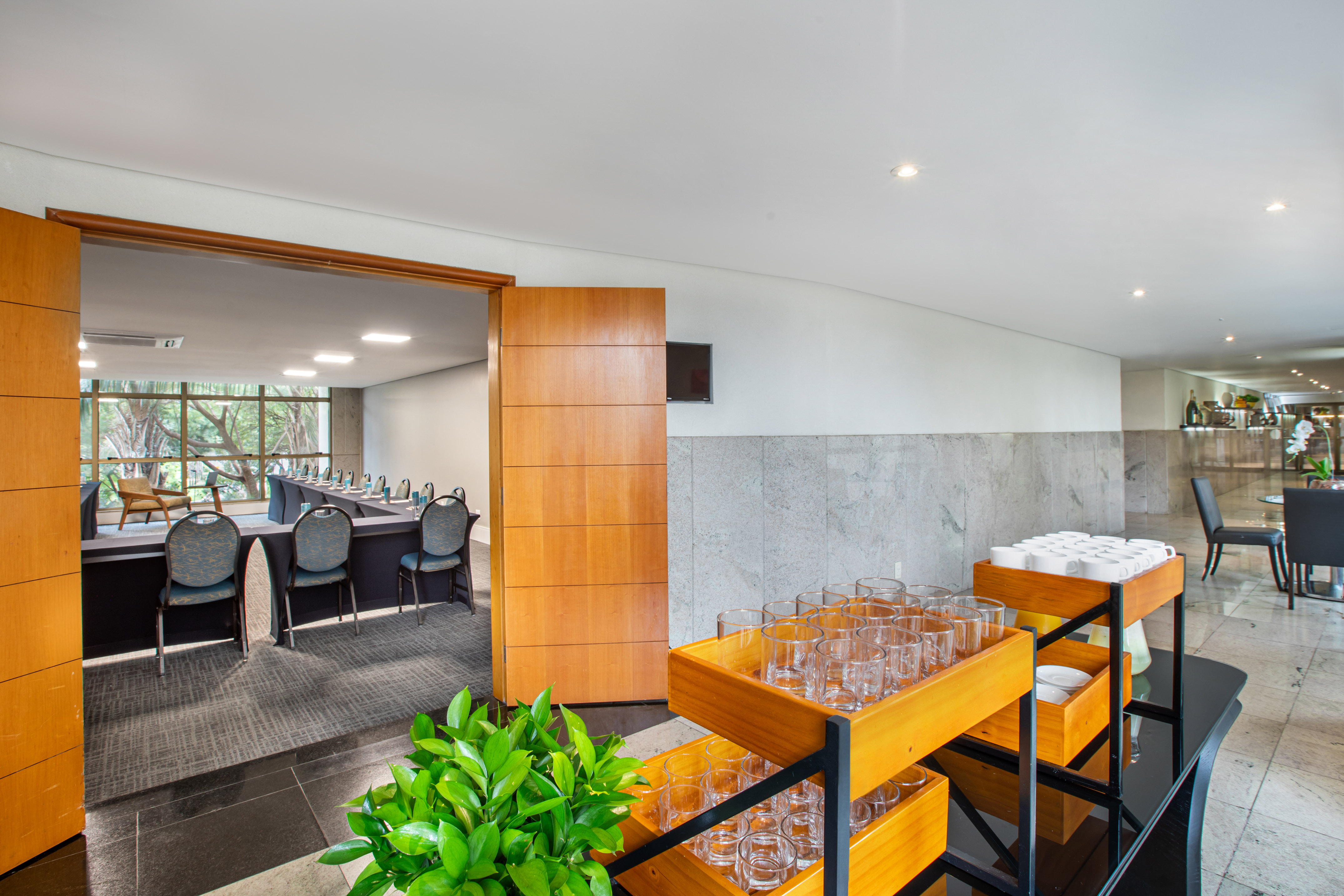 Hotel conference room with U-shaped table, adjacent refreshment station.