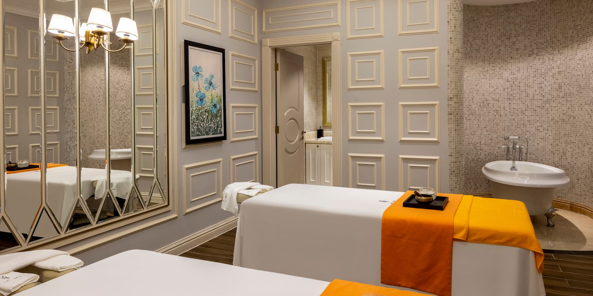 a room with white beds and a mirror