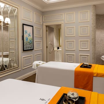 a room with white beds and a mirror